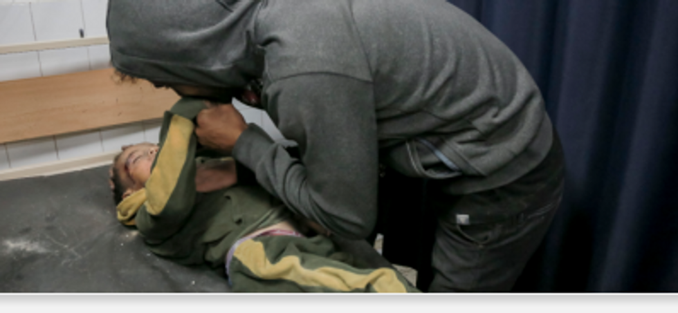 A Gazan man kisses his son, killed in an Israeli assault, good-bye.