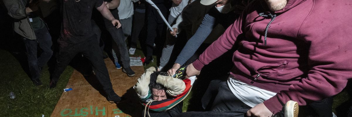 A pro-Palestinian demonstrator is beaten by a pro-Israel mob