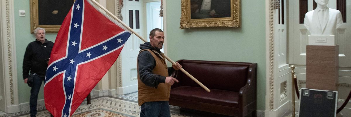 A supporter of US President Donald Trump carries a Confederate flag as he protests in the US Capitol Rotunda on January 6, 2021, in Washington, DC.