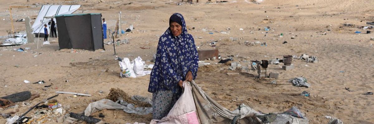 A woman folds a tent in Gaza