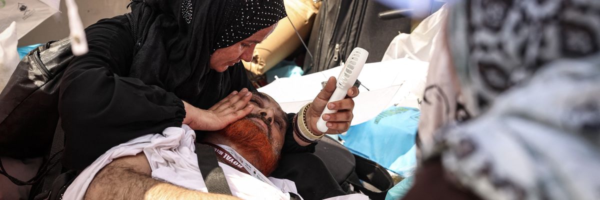 A woman helps a man who collapsed due to heat at the 2024 Hajj.