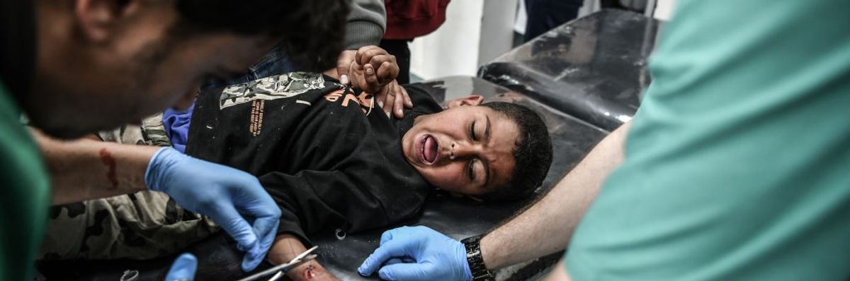 An injured Palestinian child receives medical treatment in Rafah