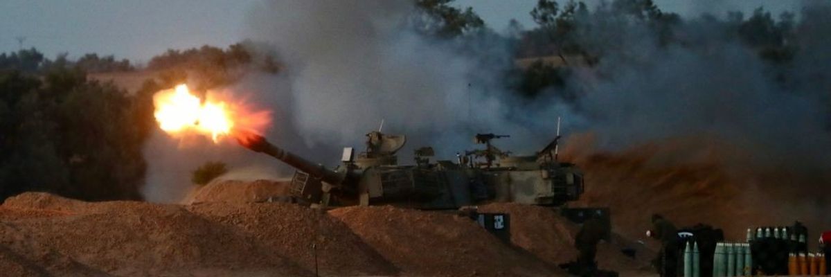 An Israeli Defense Forces self-propelled howitzer fires an artillery shell into Gaza