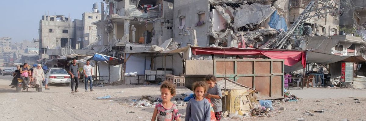 Children walk amongst the rubble