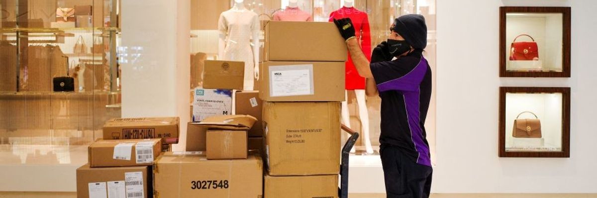 FedEx worker with stack of boxes inside shopping mall