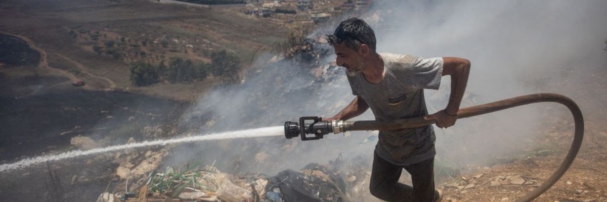 Lebanon civilian putting out fire from Israeli bombs.