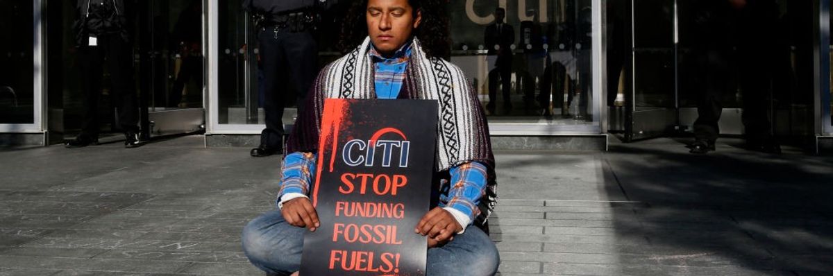 Lone protester holds sign: "Citi: Stop Funding Fossil Fuels"