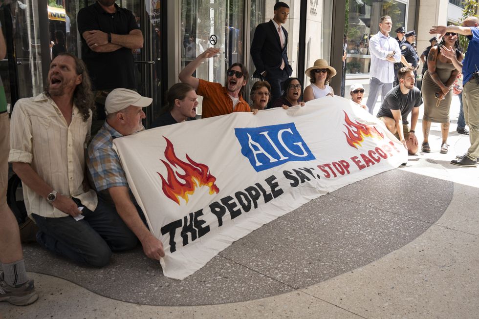 Opponents of EACOP block AIG's office with a banner 