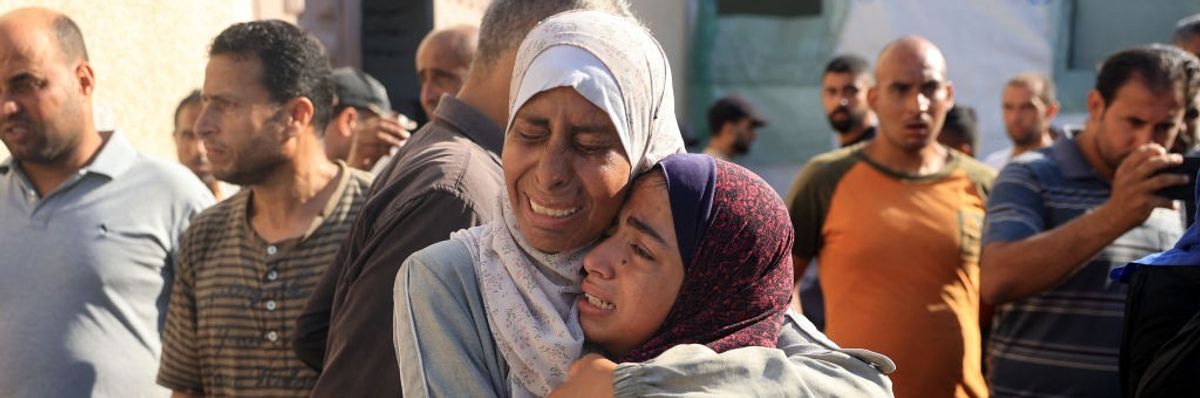 Palestinians mourn over the bodies of loved ones