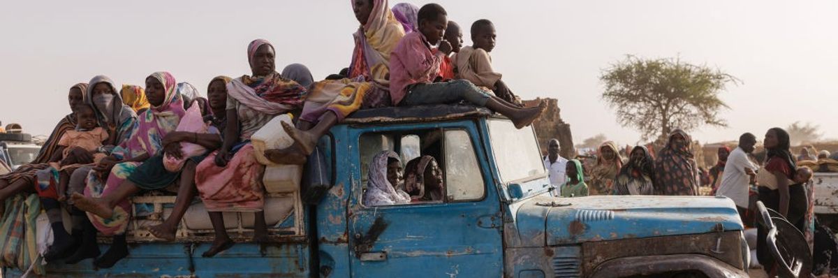 people sitting in and on top of an old truck 