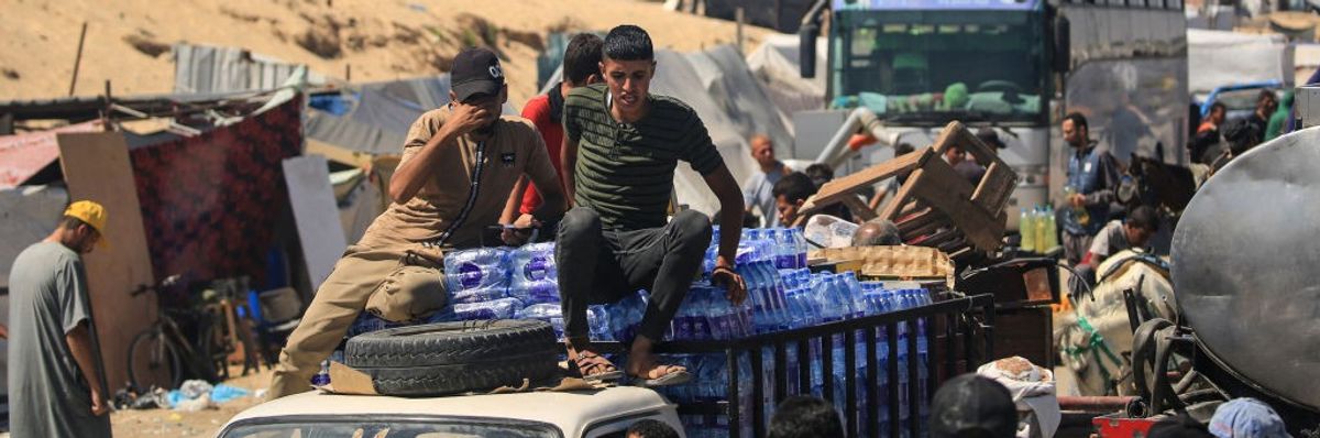 People sitting on and above vehicles as they sit in traffic in Gaza 