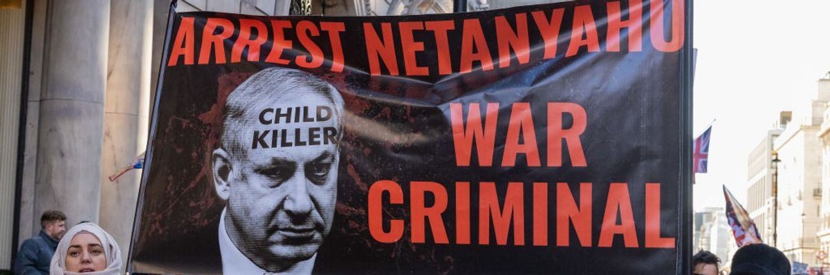Protesters hold a banner reading "Arrest Netanyahu War Criminal" in London