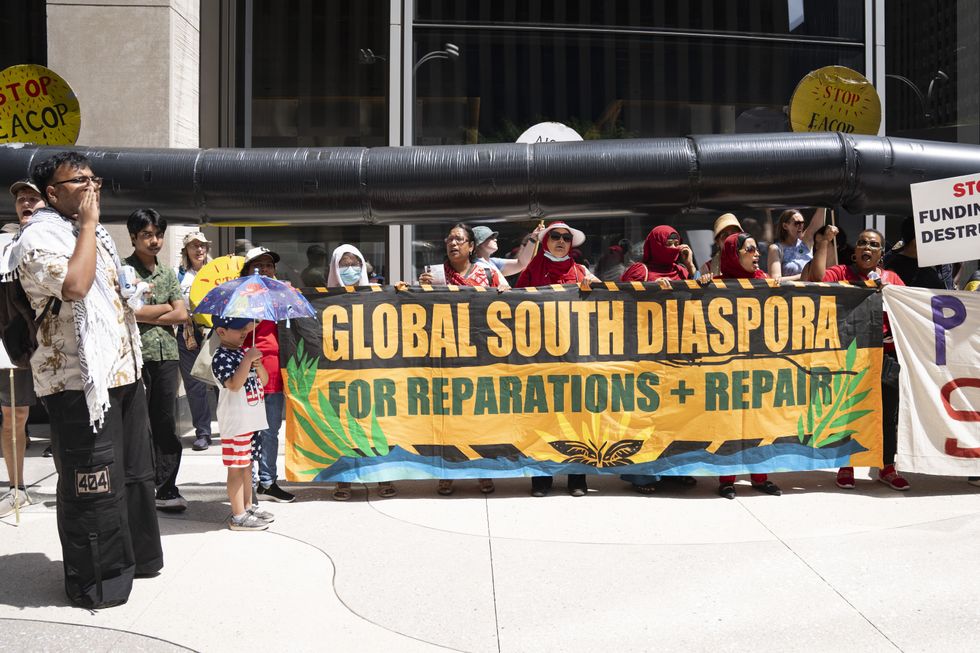 Protesters hold banner that says, Global South Diaspora for Reparations + Repair