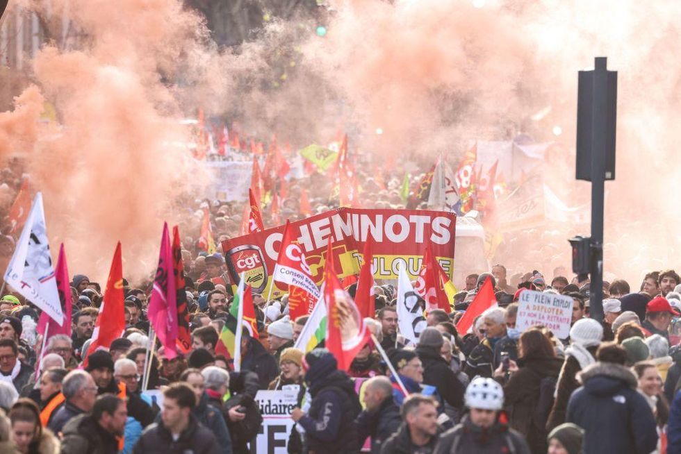 Protesters wave flags and banners during a rally called by French trade unions in Toulouse