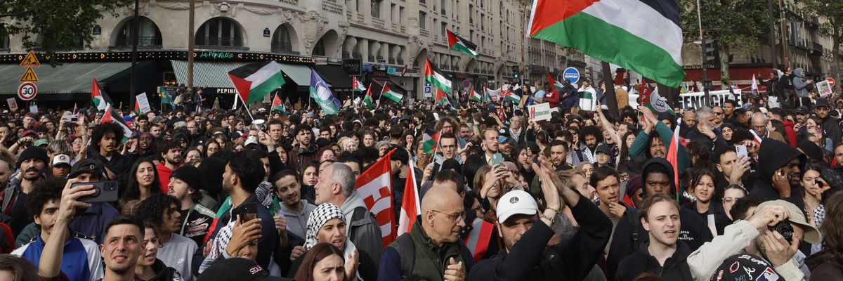 Protestors hold Palestinian flags during a demonstration in Paris