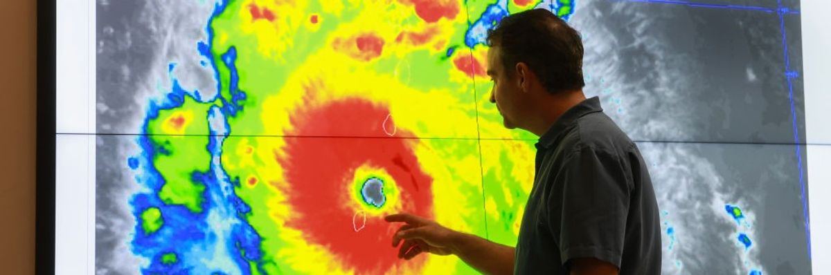 senior hurricane specialist at the National Hurricane Center inspects a satellite image of Hurricane Beryl 