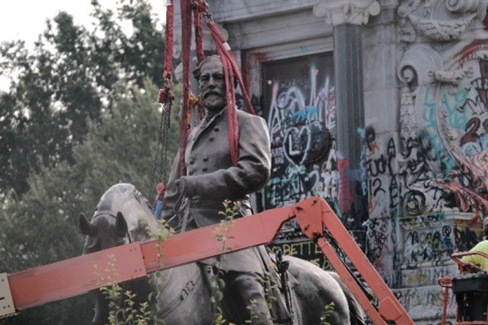 The top half of a monument to Confederate General Robert E. Lee gets hauled off in Richmond, VA in 2021.