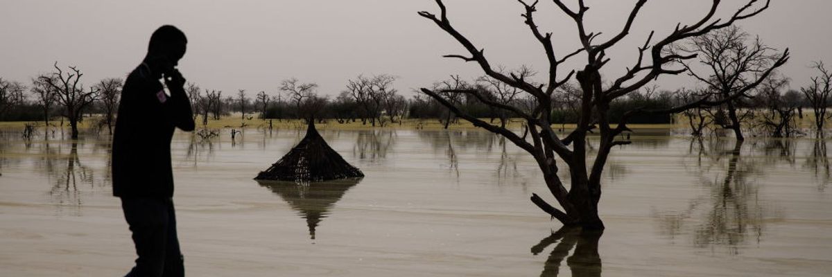 Traditional tukul houses are partly submerged in floodwaters