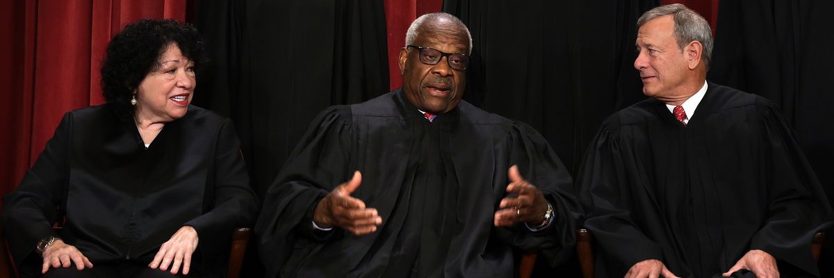 U.S. Supreme Court Justice Clarence Thomas speaks with fellow justices