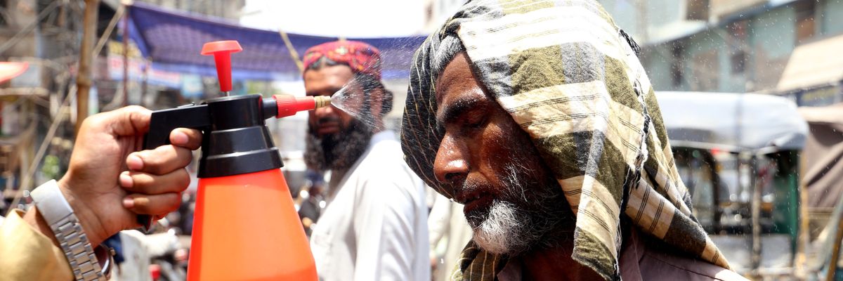 Volunteers spray water on people's faces as temperatures reached 118 degrees