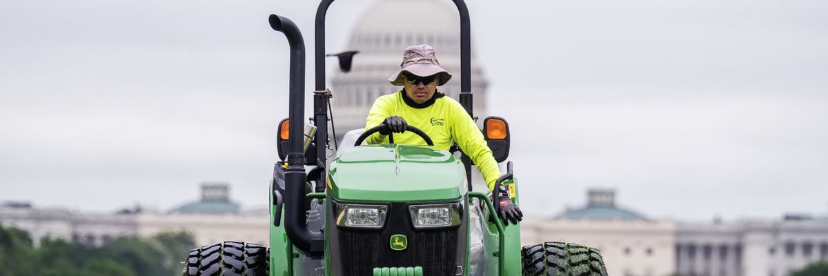 Worker mows grass on National Mall