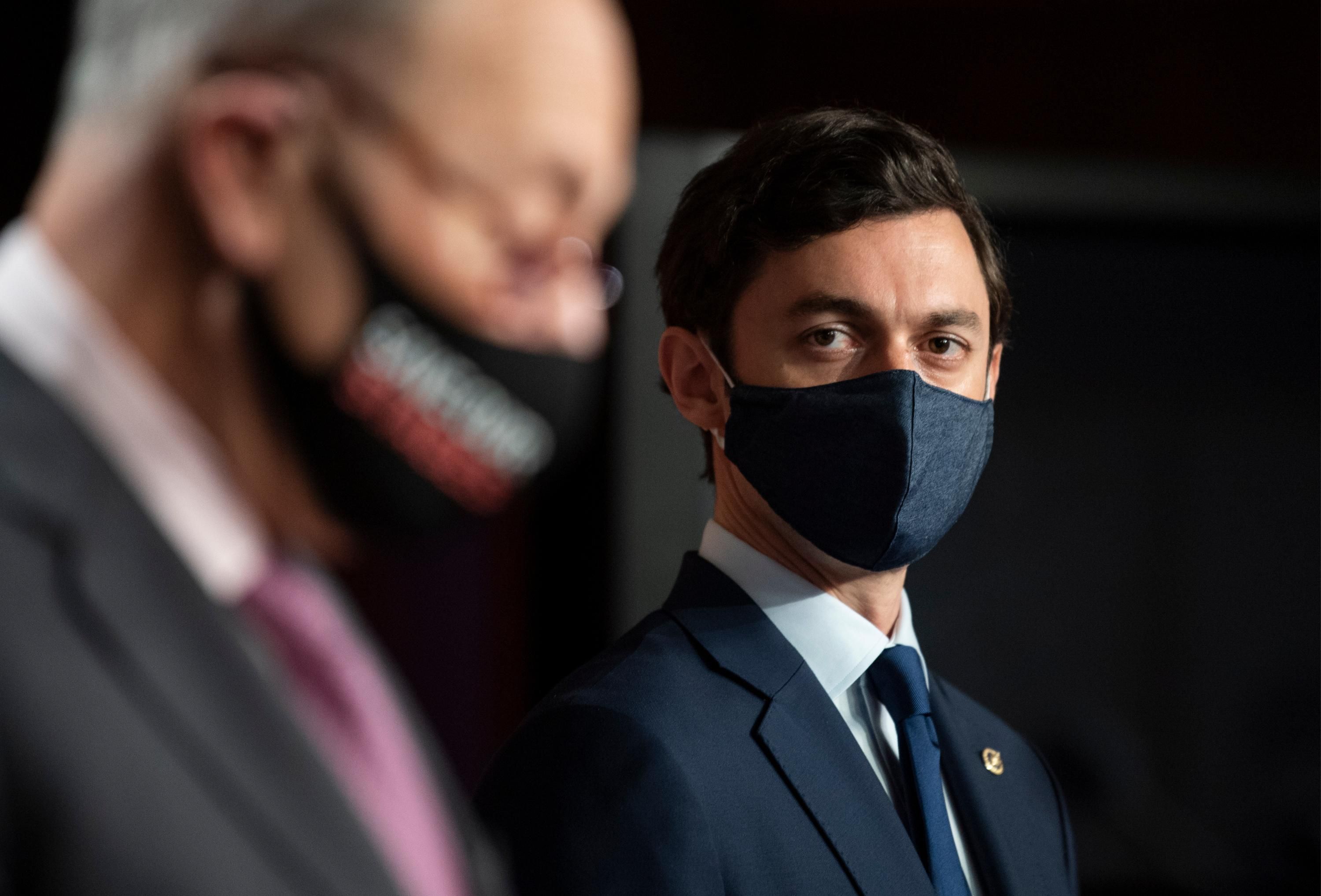 Sen. Jon Ossoff listens to Senate Majority Leader Chuck Schumer